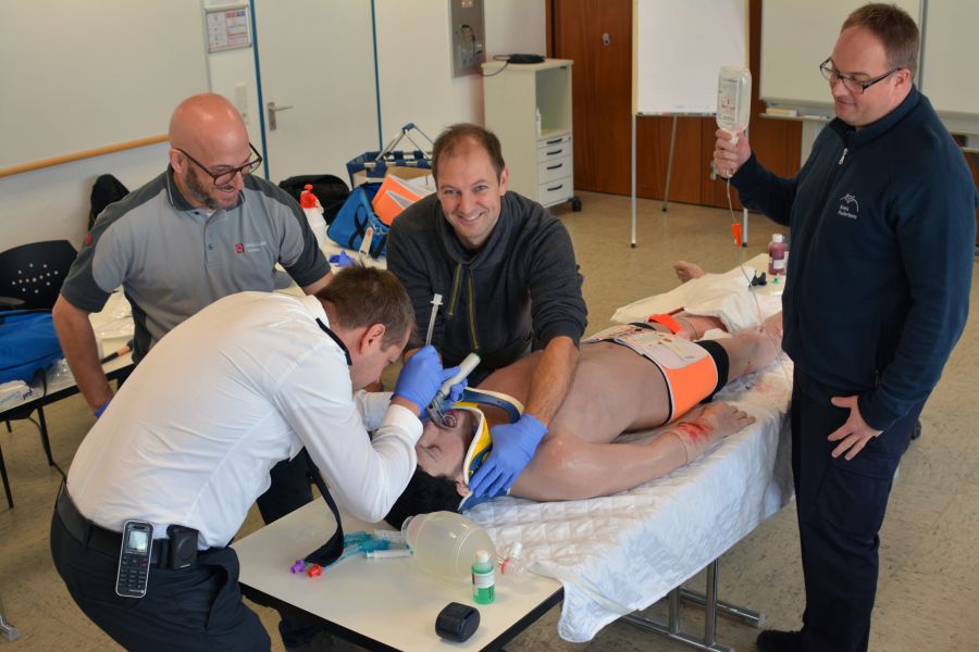 Intubieren eines Patienten lässt sich dank realistischer Darstellung des Rachens hervorragend üben – Mathias Duschel (SkillQube, links stehend) überwacht die Übung während Tobias Starke (Leiter Rettungsdienst) intubiert, assistiert von David Schule. Die Infusion hält Ausbilder Jörg Bokelmann.   links am Kopf: Herr Duschl, Fa. SkillQube den Hals fixierend: das bin ich ;) hinter dem Kopf stehend im weißen Hemd: Tobias Starke, Leiter Rettungsdienst die Infusion haltend: Jörg Bokelmann, Ausbilder Bildrechte: Kreis Paderborn, Amt für Presse- und Öffentlichkeitsarbeit, Meike Delang